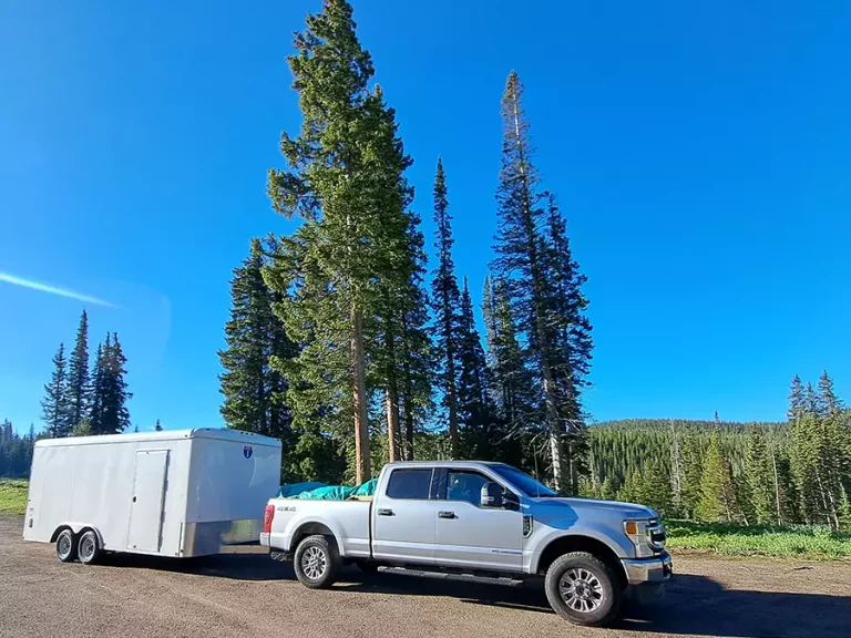 A truck loaded with a yurt hauling a cargo trailer loaded with yurt