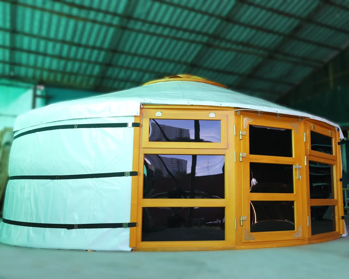 A Mongolian yurt with glass windows at two sides of the door, in white cover and yellow wood painting
